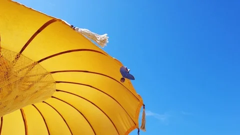  yellow parasol the wind develops tassels hanging from the tips of the umbrella. Stock Footage 109534145