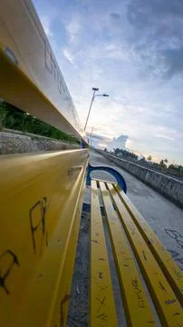 Yellow Park Bench Under Cloudy Sky Stock-Fotos