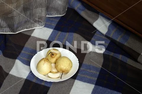 Yellow pears in a white plate lie on a blue caged plaid Stock Photos