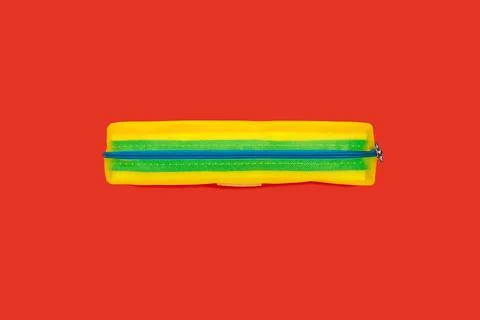 Yellow pencil case on a red surface Stock Photos