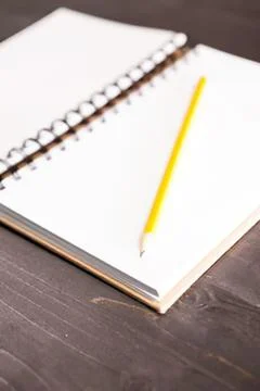 Yellow pencil resting on open notebook Stock Photos