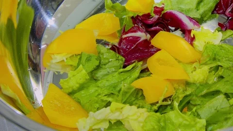 Yellow pepper falling on lettuce leaves Видео 70985900