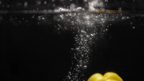 Yellow pepper falling into water Stock Footage 254584943