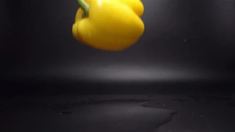 Yellow Pepper Falling in Water with Splash in Slow Motion Stock Footage 104726858