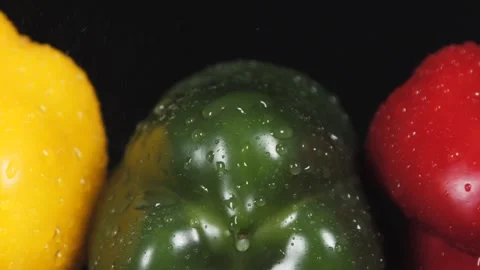 Yellow pepper, red pepper and green pepper on black background. Stock Footage 140498139