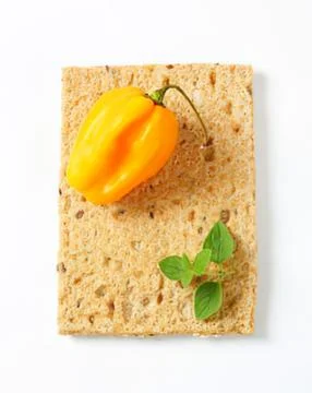 Yellow pepper on textured sponge with basil Stock Photos