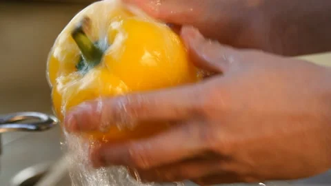 Yellow pepper under running water Stock Footage 87037564