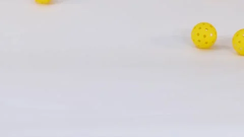 Yellow Perforated Plastic Balls Falling and Bouncing on White Surface 스톡 동영상 329144239