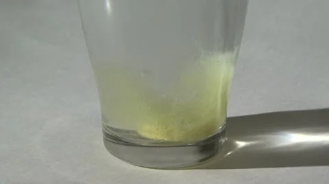 Yellow pill dissolves in water Stock Footage 10825749