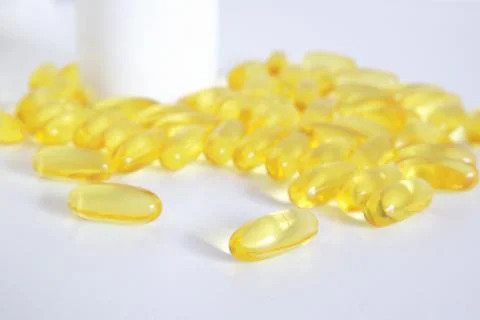Yellow pills on a white table Stock Photos