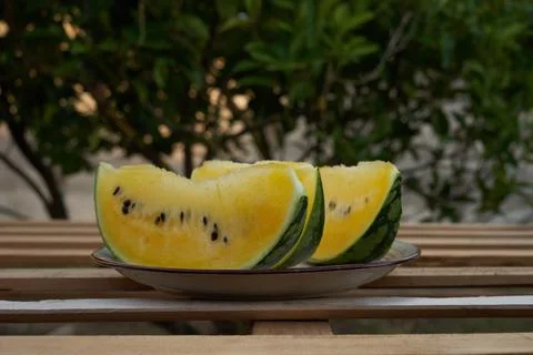 Yellow pineapple watermelon sliced on the table in the background tree greenery Stock Photos