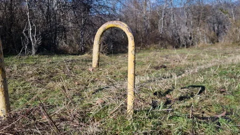 Yellow pipeline marker post indicating an underground natural gas or oil line in Stock Footage 327729081