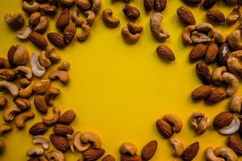 Yellow place to insert, surrounded by cashews and almonds. Stock Photos