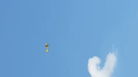 Yellow plane does dangerous stunts in the sky Stock Footage 99225059