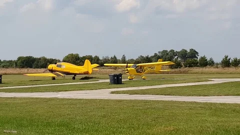 Yellow plane with a propeller landed on the field at the airfield Video stock 104044444