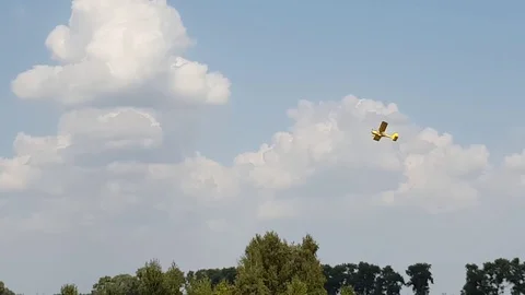 Yellow plane rises into the blue sky and flies in the clouds. Video stock 104444542