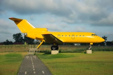 A yellow plane is standing on the ground; Stock Photos
