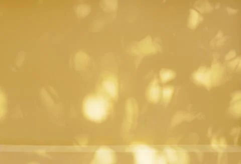 Yellow plaster wall product backdrop with leaves shadow Stock Photos