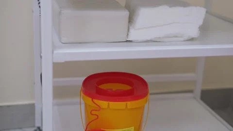 Yellow plastic bucket with red lid placed on a white shelf alongside two blocks Stock Footage 329102934