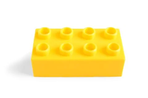 Yellow plastic building block on white background Stock Photos