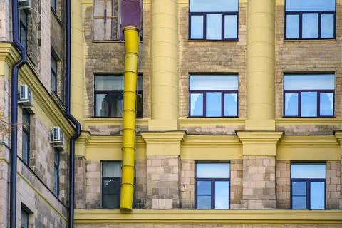 Yellow plastic composite pipe for dumping construction debris on the window o Stock Photos