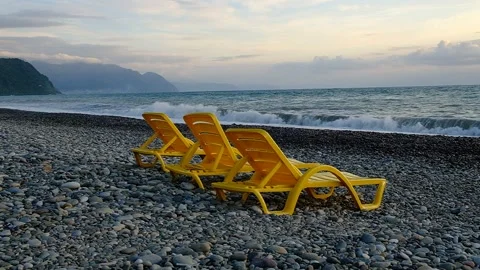 Yellow plastic sunbeds on the seashore. Video stock 134876790