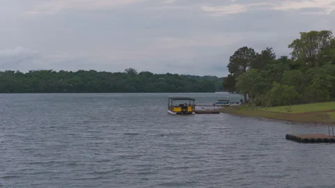 Yellow Pontoon Boat Moored at Dock on Calm Forest Lake 動画素材 346077498