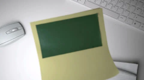 Yellow post it with green copy space falling on office desk Stock Footage 23377390
