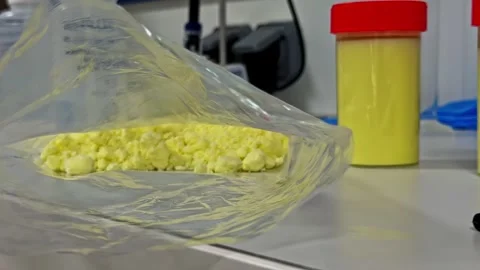 Yellow Powder in Plastic Bag on Laboratory Table with Sample Jars and Lab Stock Footage 341539697