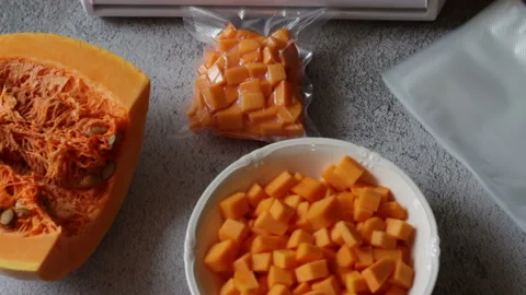 Yellow pumpkin cut into slices and cubes and vacuum packed Stock-Footage 147716005