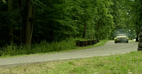 Yellow Race Car Speeds Along A Winding Forest Hillclimb Track Vídeo Stock 340262049