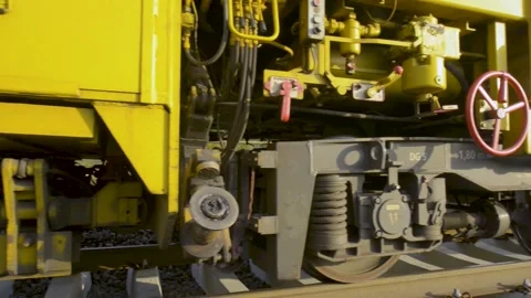 Yellow Rail Maintenance Machine Axle and Suspension Moving Along Train Tracks Stock Footage 334053792