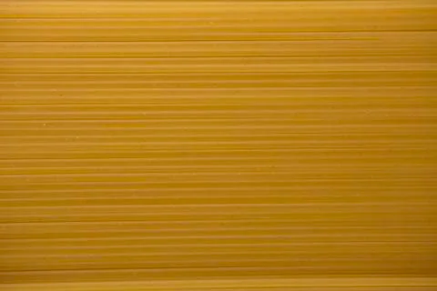 Yellow raw spaghetti background texture close up. Stock Photos