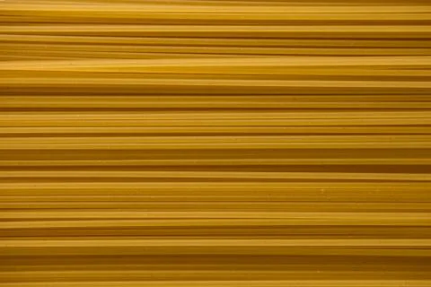 Yellow raw spaghetti background texture close up. Stock Photos