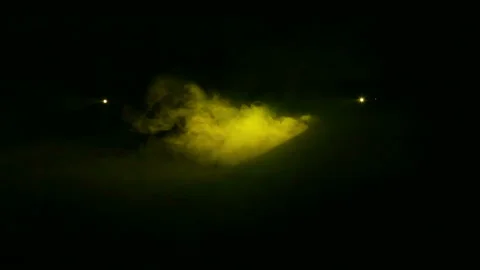 Yellow rays of light from profile spotlights in the dark in a smoke blanket 库存影片 119925063