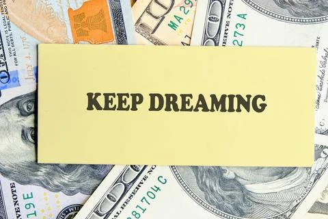 A yellow rectangle with KEEP DREAMING in bold text rests atop scattered United Stock Photos