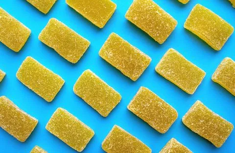 Yellow rectangular shaped marmalade on colorful pattern. Stockfoto's