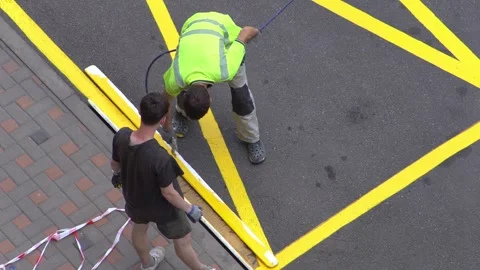 Yellow rectangular sign prohibiting parking on asphalt. Workers apply road Stockbeeldmateriaal 318947728