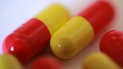 Yellow-red capsule pills. Macro focus Видео 88764449