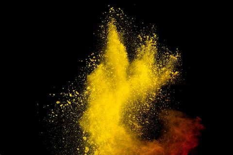 Yellow red powder explosion cloud on black background. Stock Photos