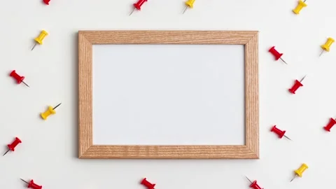 Yellow red push pins and wooden frame on white background. Stop motion Stock Footage 147706079