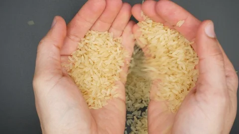Yellow rice in the hands 库存影片 128314774