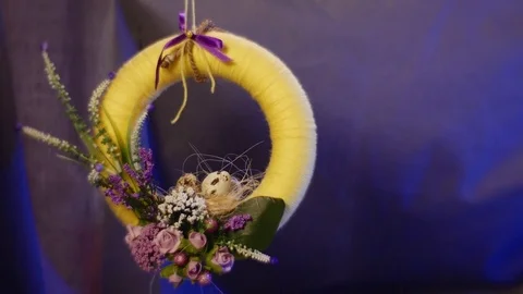 A Yellow Ring With a Bunch of Field Flowers is Hanging Over a Table in Studio Stock Footage 72887186