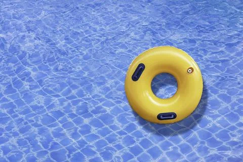 Yellow ring floating in a blue wave water on the outdoor swimming pool. Summe Stock Photos