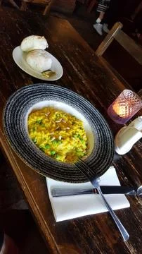 Yellow Risotto Plate on Rustic Table Stock Photos