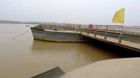 The yellow river, flowing peacefully through a pontoon bridge in the winter Stock Footage 34880903