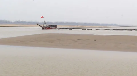 The yellow river, flowing peacefully in the winter, and the boat in a harbor Stock Footage 34881329