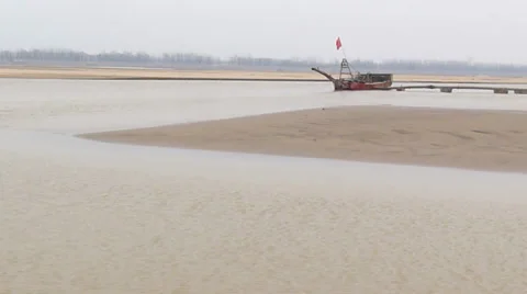 The yellow river, flowing peacefully in the winter, and the boat in a harbor Stock Footage 34883122