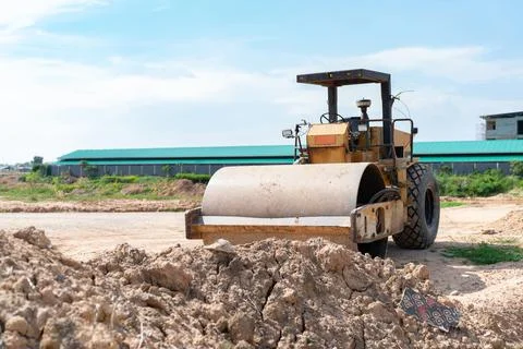 Yellow roadroller in place of future construction Stock Photos