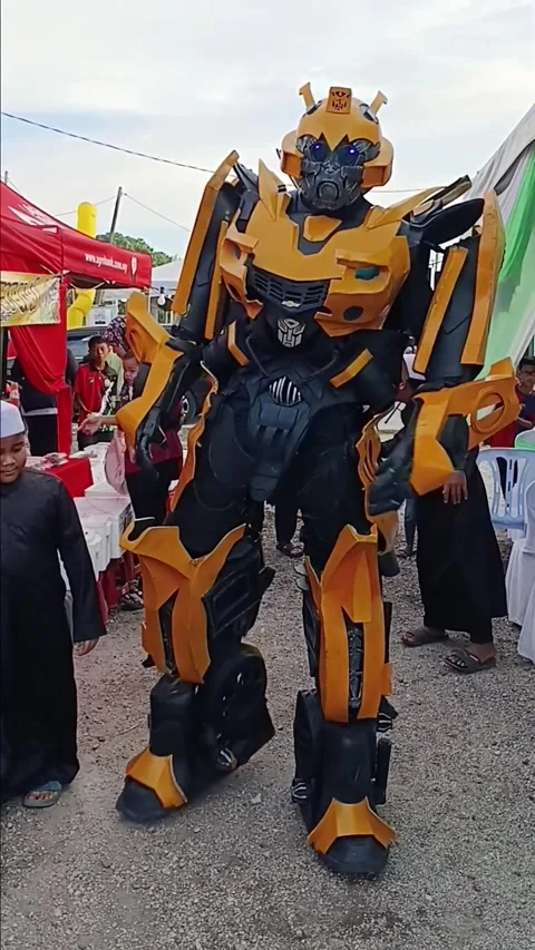 Yellow Robot Transformer Performer Interacting with Families at Outdoor Event Video stock 321120449